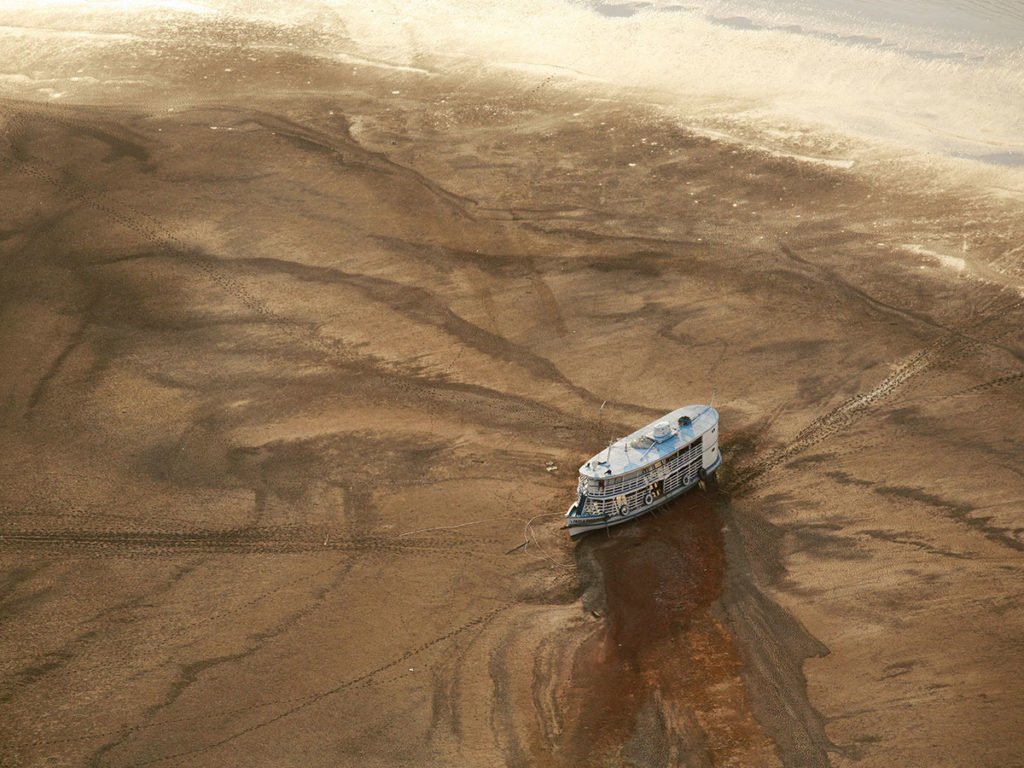 Grande embarcação fluvial presa em um banco de areia a leste de Barreirinha, durante uma das piores secas já registradas na Amazônia.